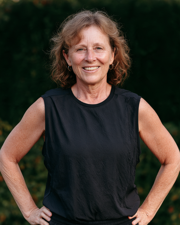 Smiling woman in black activewear with hands on her hips